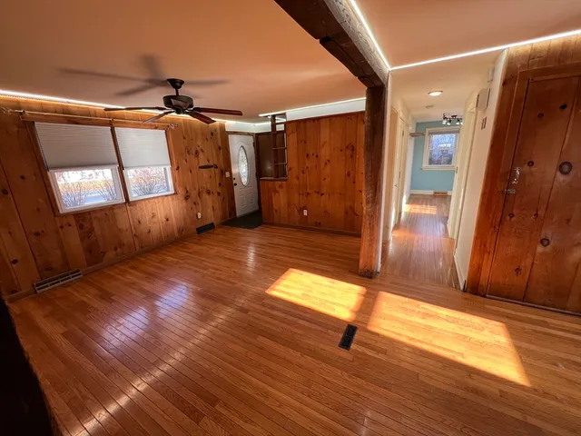 a view of empty room with wooden floor