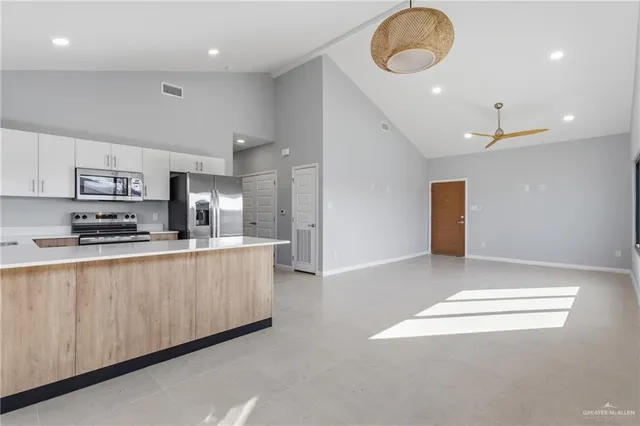 a large kitchen with stainless steel appliances lots of counter space and a refrigerator