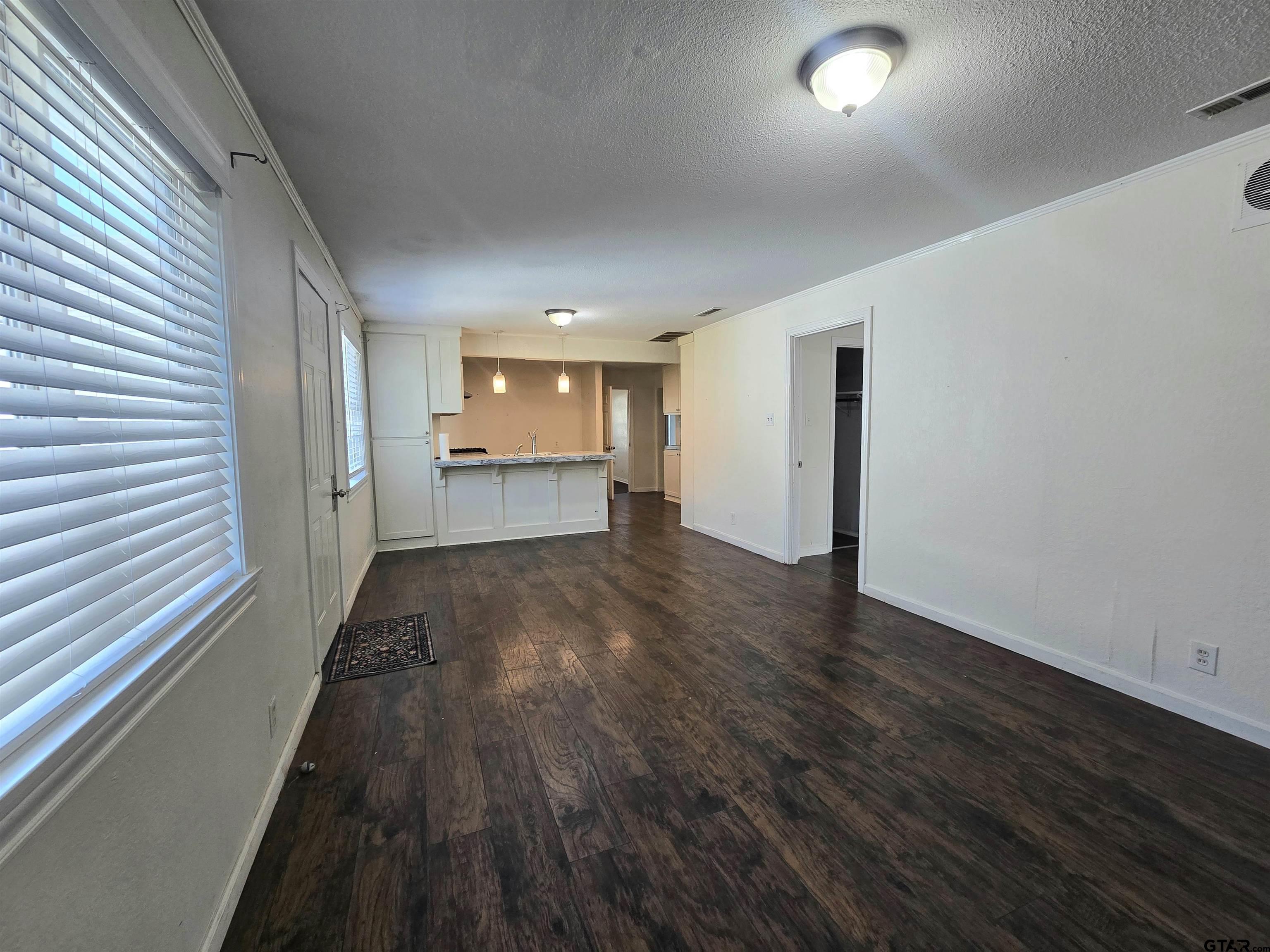 3623 New Copeland Road Tyler, TX 75701 - Photo 12 of 42 an empty room with wooden floor and windows