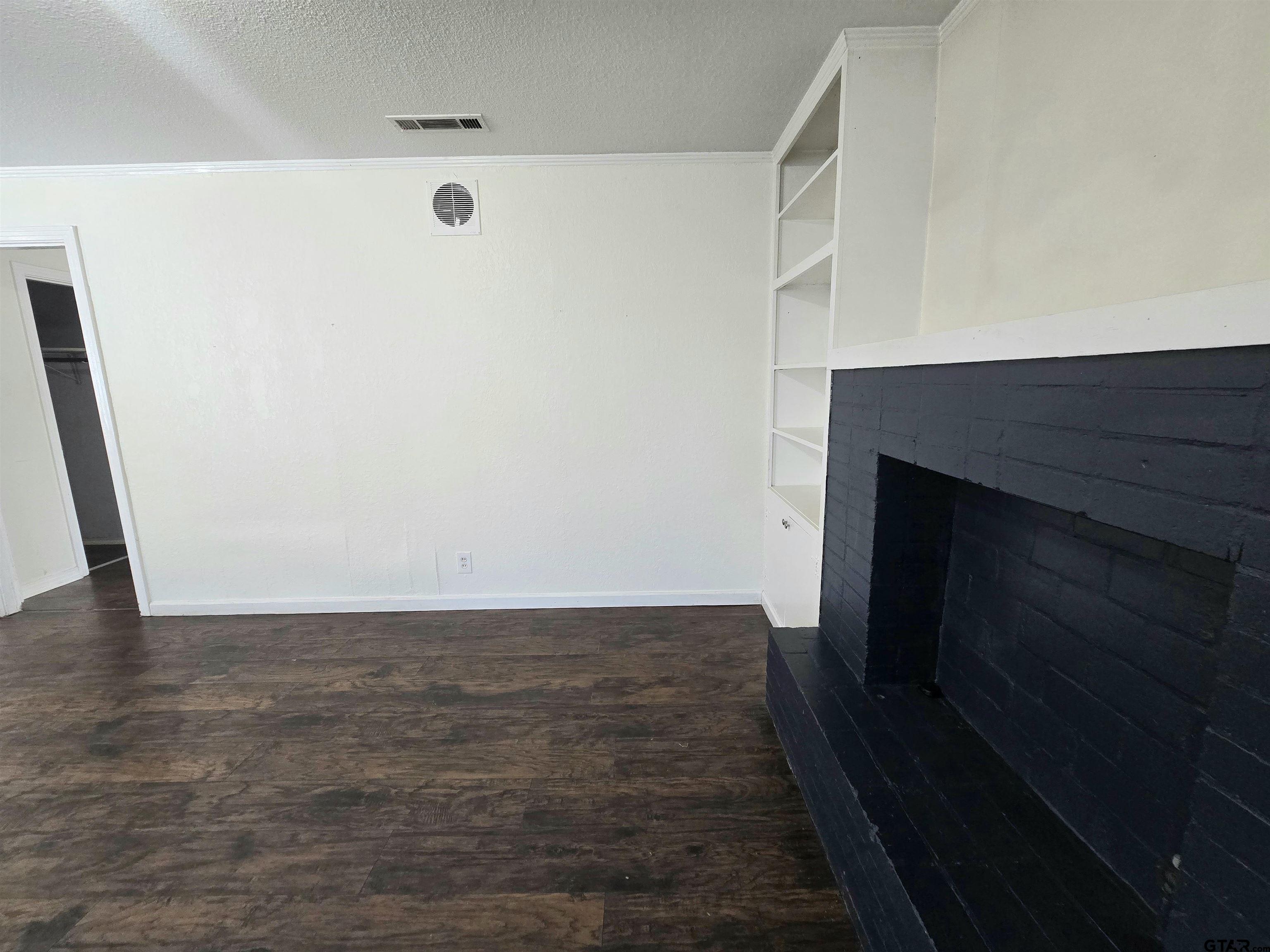 3623 New Copeland Road Tyler, TX 75701 - Photo 14 of 42 a view of an empty room with wooden floor and a fireplace