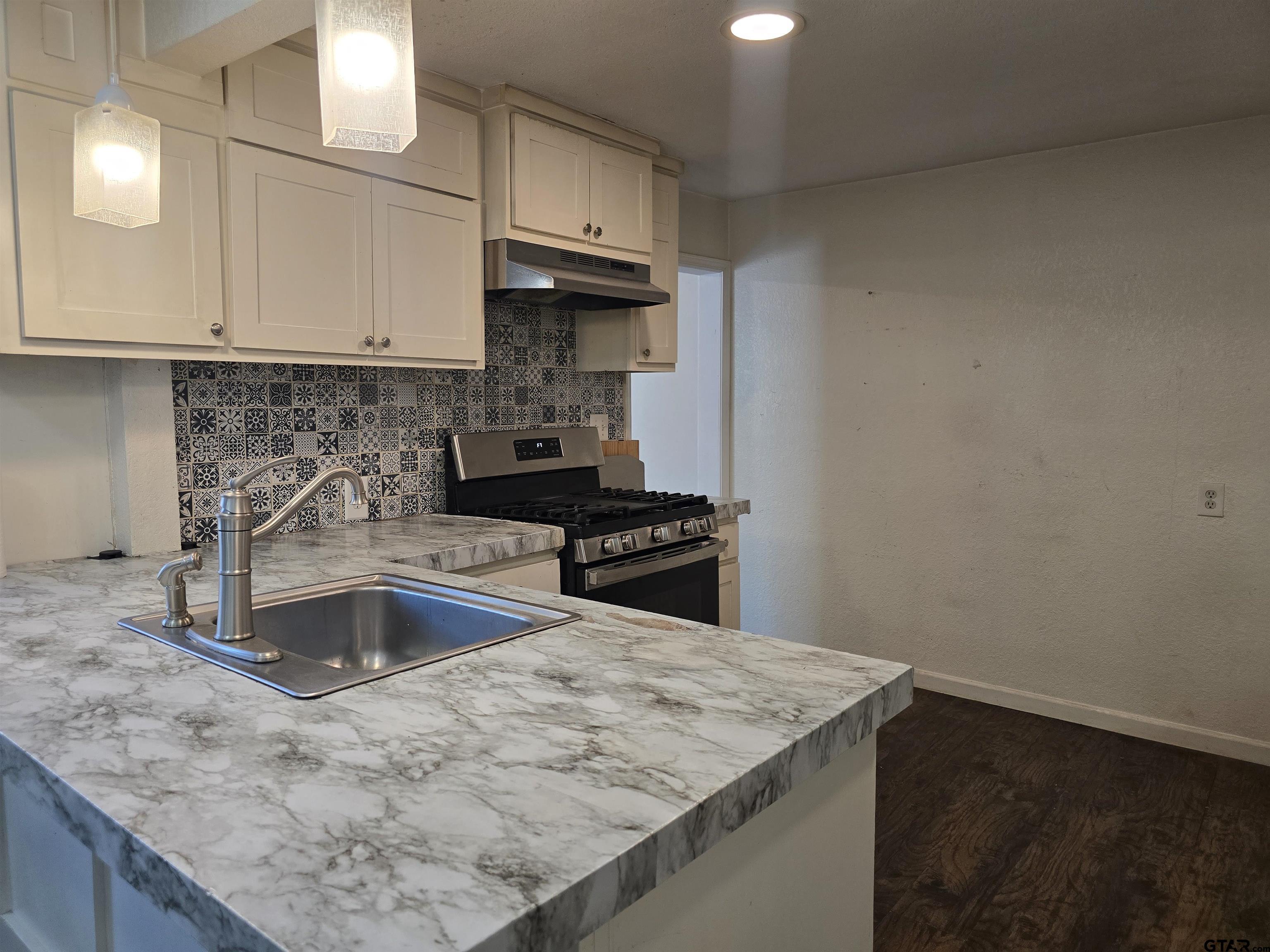 3623 New Copeland Road Tyler, TX 75701 - Photo 15 of 42 a kitchen with granite countertop a sink and a stove
