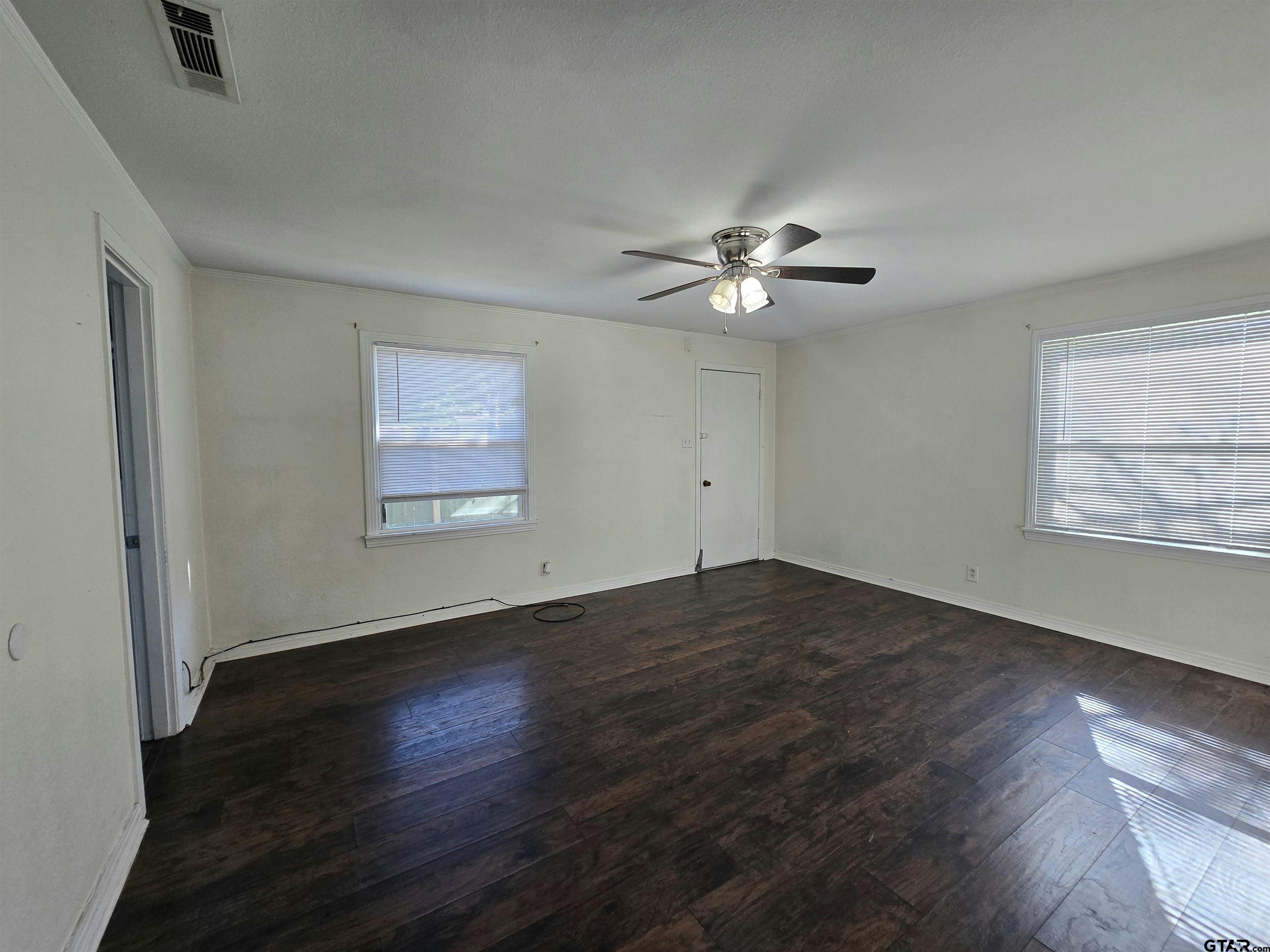 3623 New Copeland Road Tyler, TX 75701 - Photo 20 of 42 an empty room with wooden floor chandelier fan and windows