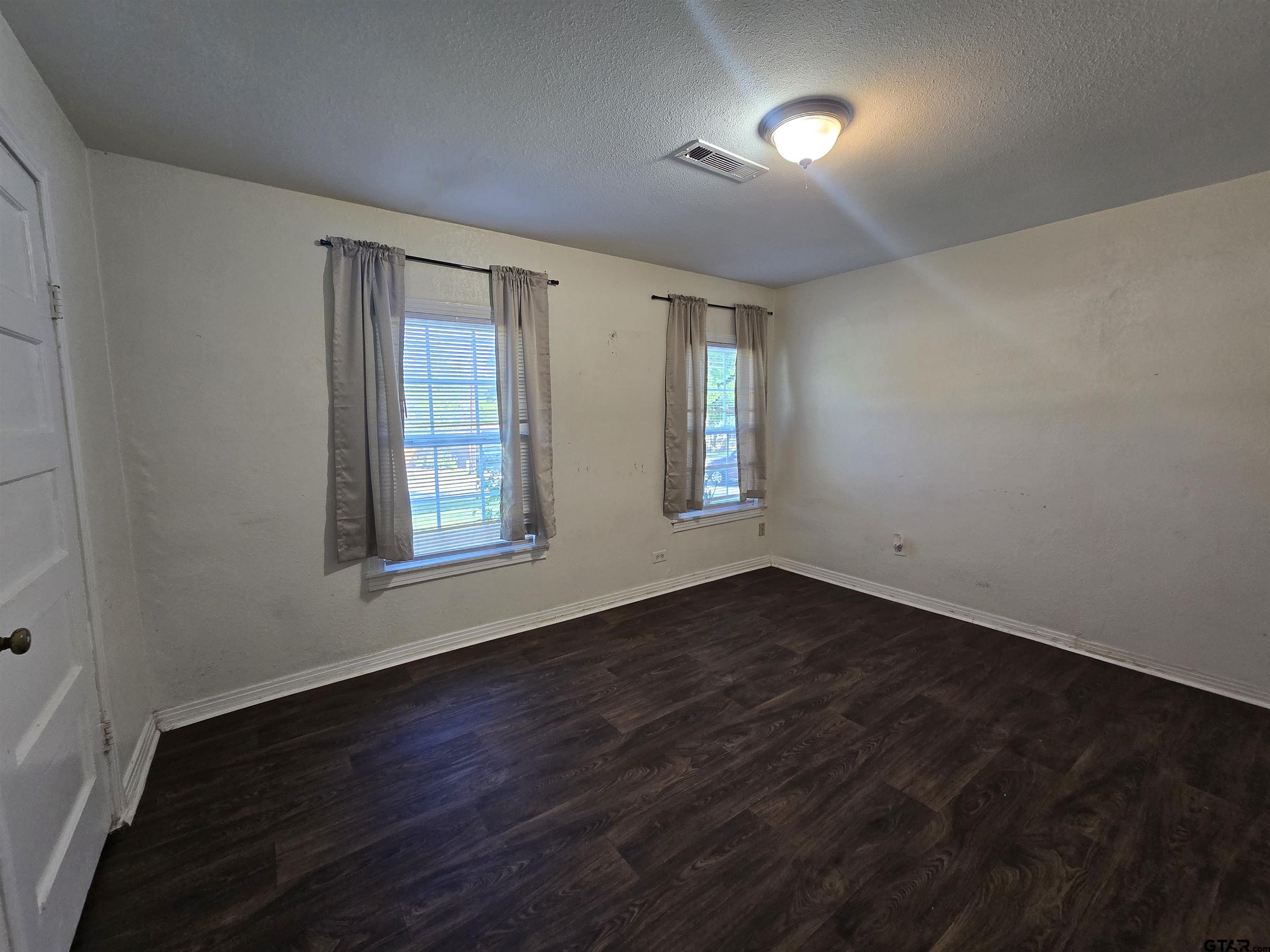 3623 New Copeland Road Tyler, TX 75701 - Photo 28 of 42 an empty room with wooden floor and windows