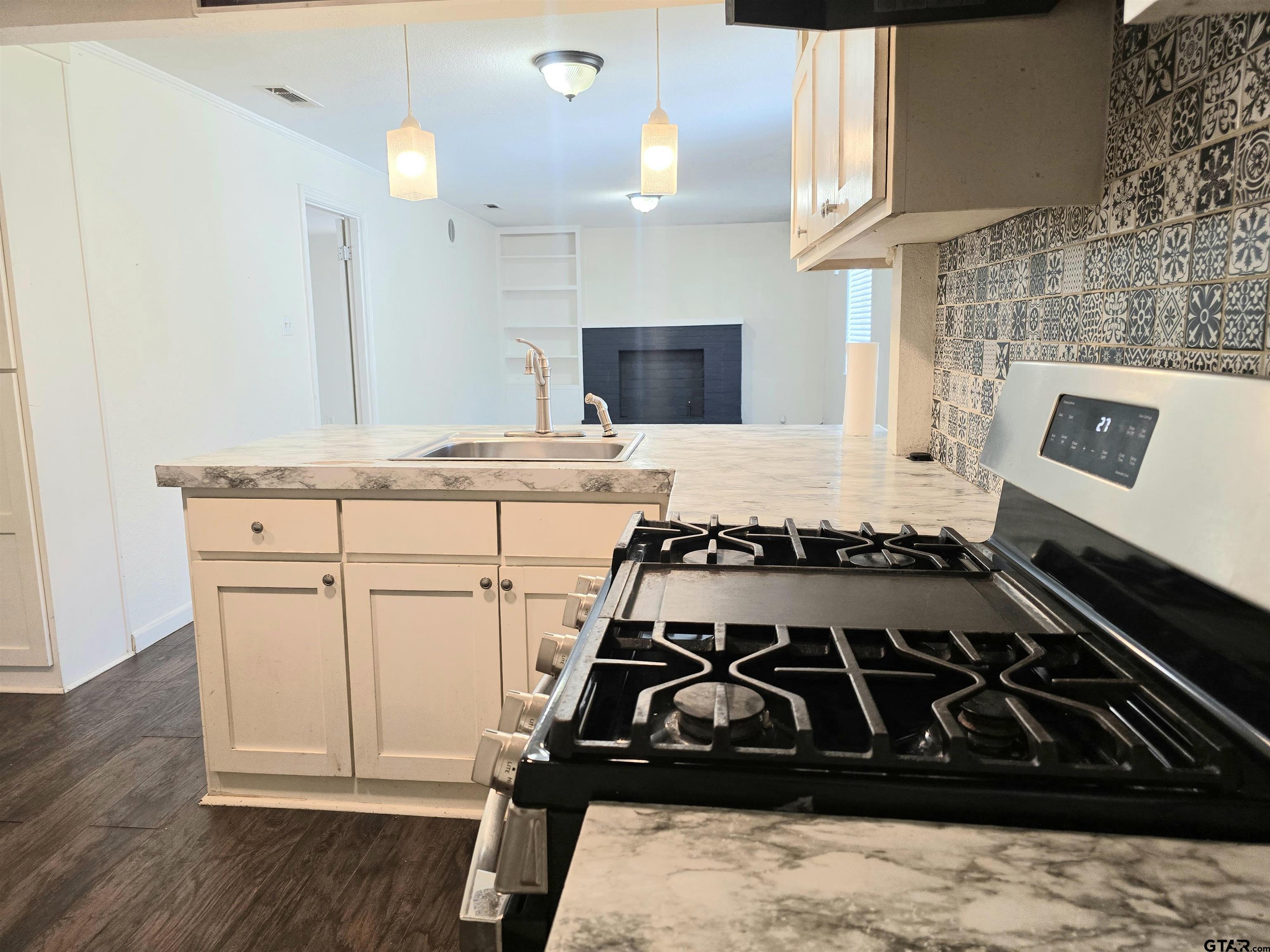 3623 New Copeland Road Tyler, TX 75701 - Photo 8 of 42 a kitchen with a stove and a wooden cabinets