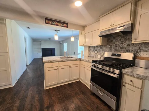 a kitchen with kitchen island a sink wooden floor and a fireplace