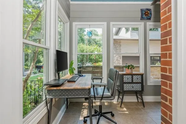 a view of a workspace with furniture and a window