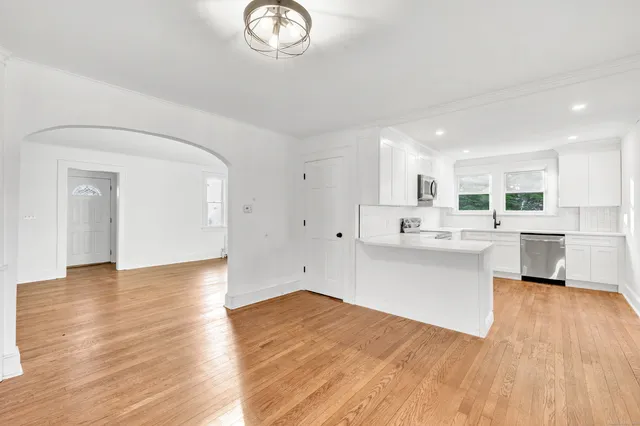 a kitchen with stainless steel appliances a white stove top oven sink and cabinets