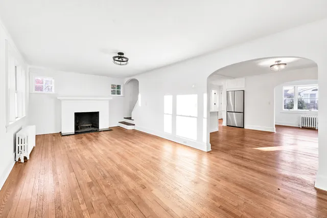 a view of empty room with wooden floor and fireplace