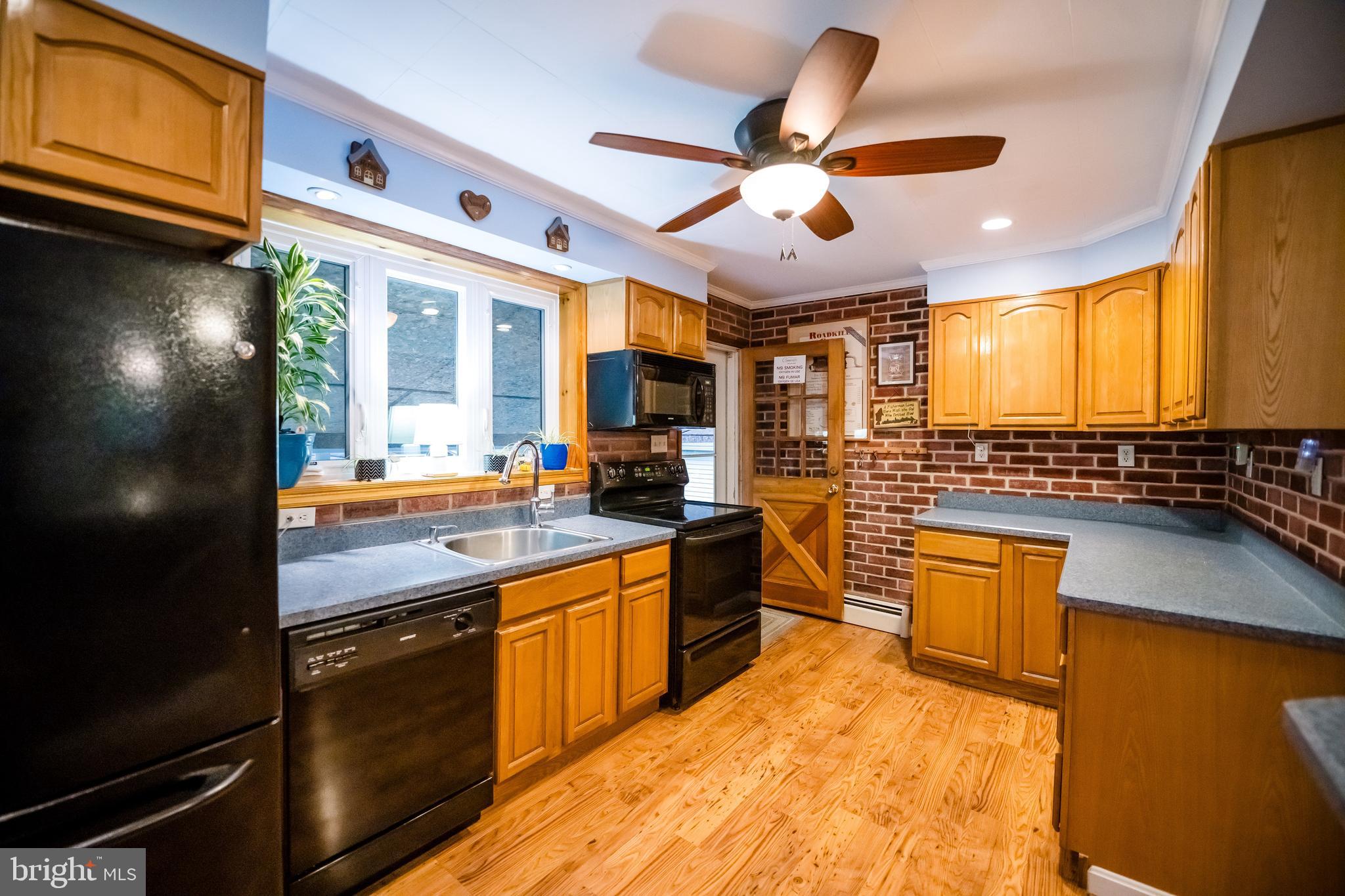 1107 Maple Road Essex, MD 21221 - Photo 28 of 42 a kitchen with stainless steel appliances granite countertop a sink a stove and a refrigerator