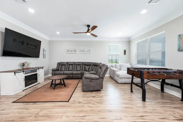 a living room with furniture a flat screen tv and a wooden floor