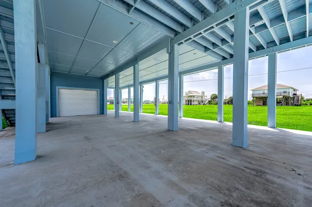 a view of an empty room with floor to ceiling window and wooden fence