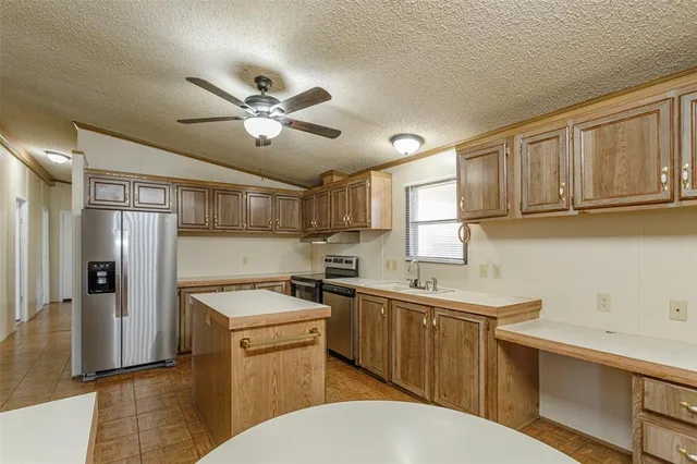a kitchen with a sink a refrigerator and cabinets