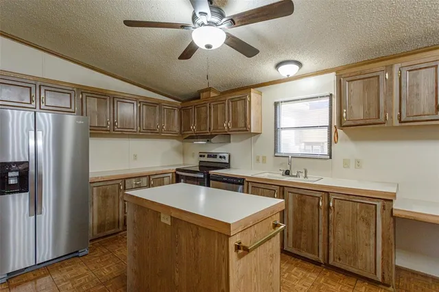 a kitchen with stainless steel appliances granite countertop a sink stove and cabinets