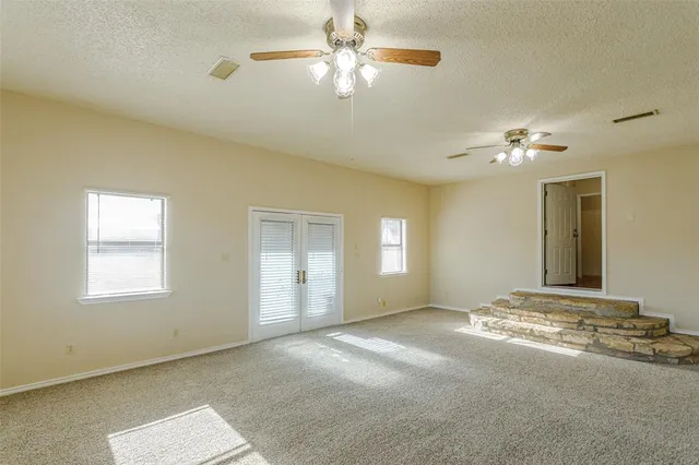 an empty room with a chandelier fan and a chandelier fan