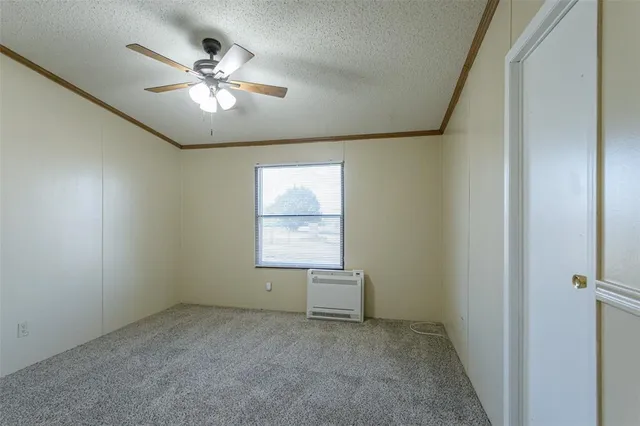 an empty room with a window and a fan