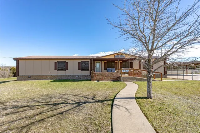 a backyard of a house with table and chairs
