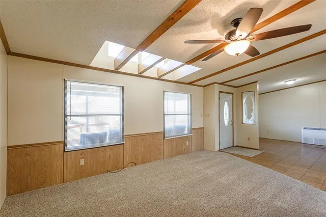 an empty room with windows and ceiling fan