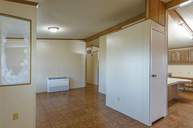 an empty room with windows fireplace and fans