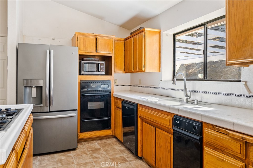 3880 Ardilla Road Atascadero, CA 93422 - Photo 15 of 60 a kitchen with stainless steel appliances granite countertop a refrigerator and a sink