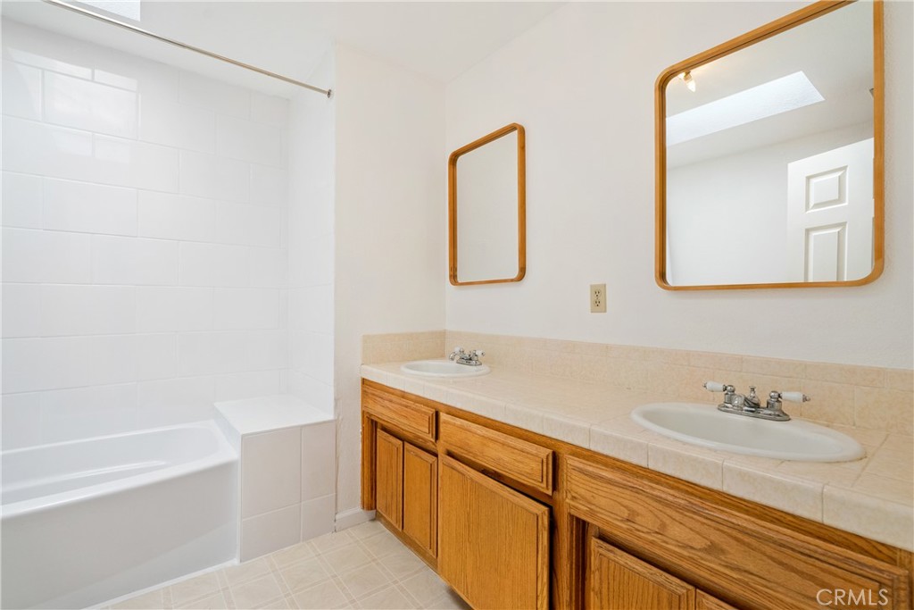 3880 Ardilla Road Atascadero, CA 93422 - Photo 30 of 66 The main bathroom has a large double sink vanity and a tub/shower combination.