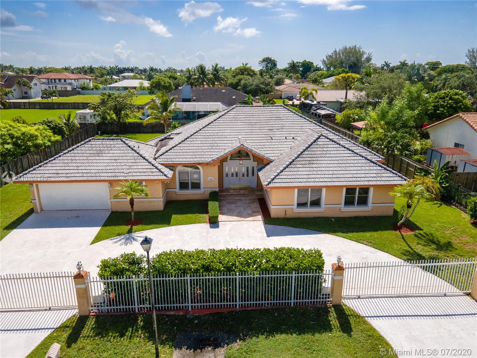 a view of house with a big yard and potted plants