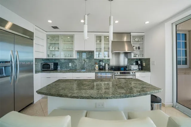 a view of kitchen with stainless steel appliances granite countertop a sink a stove and a refrigerator