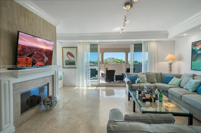 a living room with furniture a fireplace and a large window