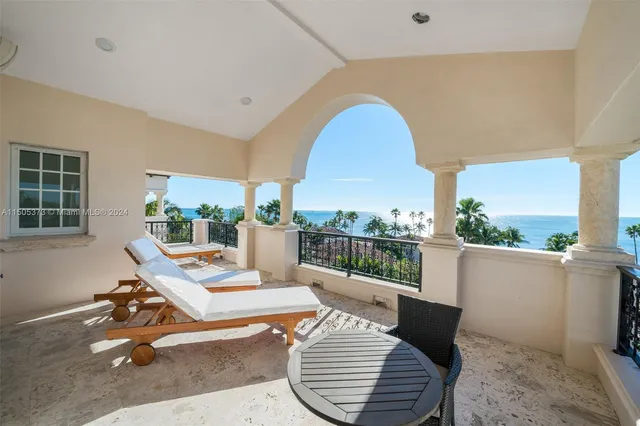 a living room with furniture a rug potted plant and a large window