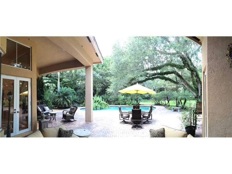 3700 Shady Ridge Road Fort Lauderdale, FL 33312 - Photo 14 of 17 a view of a patio with a table and chairs under an umbrella