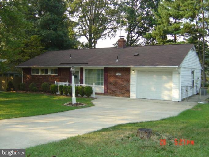 7205 Highland Street Springfield, VA 22150 - Photo 1 of 12 a front view of a house with a garden and yard