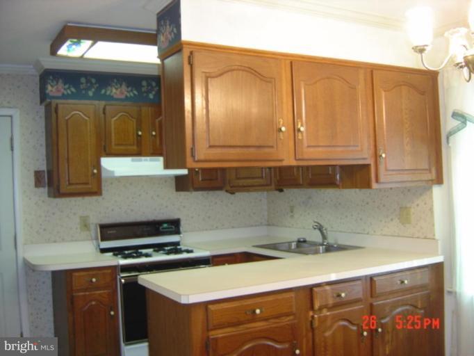 7205 Highland Street Springfield, VA 22150 - Photo 3 of 12 a kitchen with granite countertop a sink a stove and cabinets