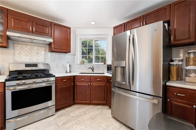 a kitchen with stainless steel appliances a refrigerator stove and microwave