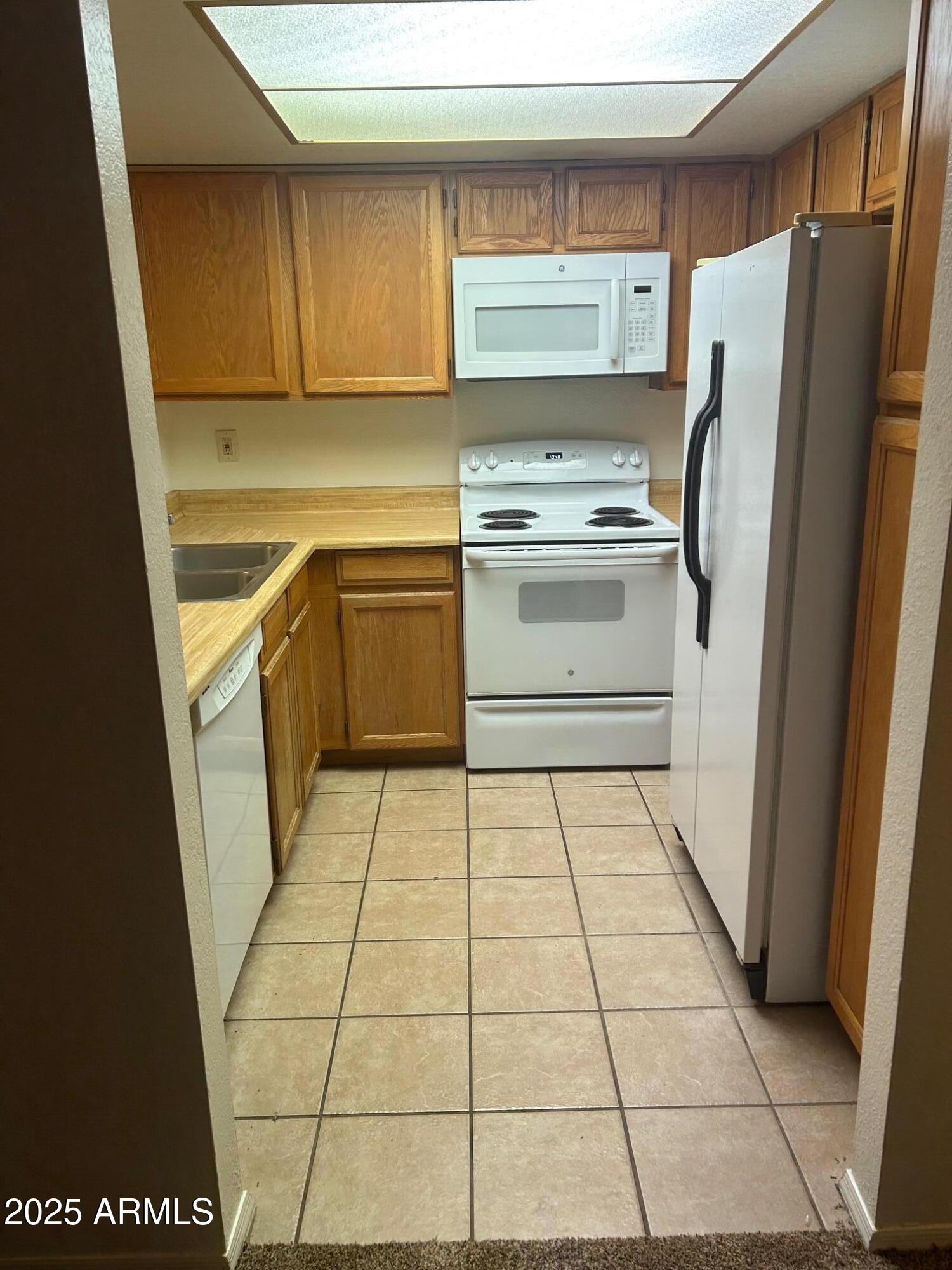 1645 West Baseline Road, Unit 1079 Mesa, AZ 85202 - Photo 2 of 19 a kitchen with a cabinets and a stove top oven