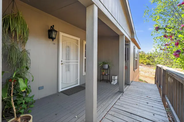 a living room with stainless steel appliances furniture and a kitchen view