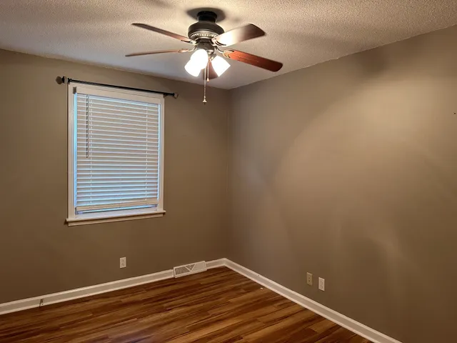 a view of a room with wooden floor and fan