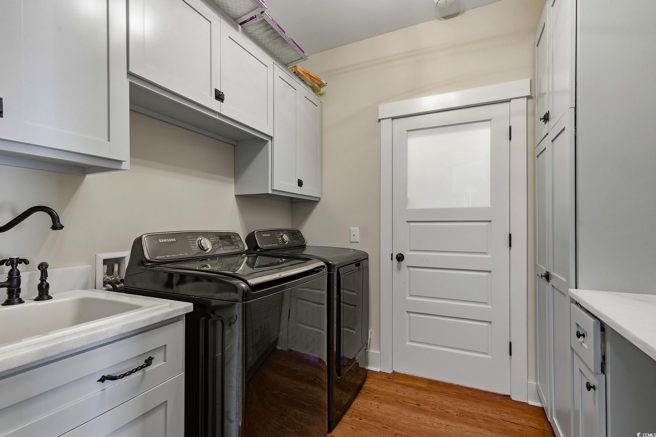 851 Dog Bluff Road Galivants Ferry, SC 29544 - Photo 15 of 25 Laundry room with cabinet space, light wood-style flooring, and washing machine and clothes dryer