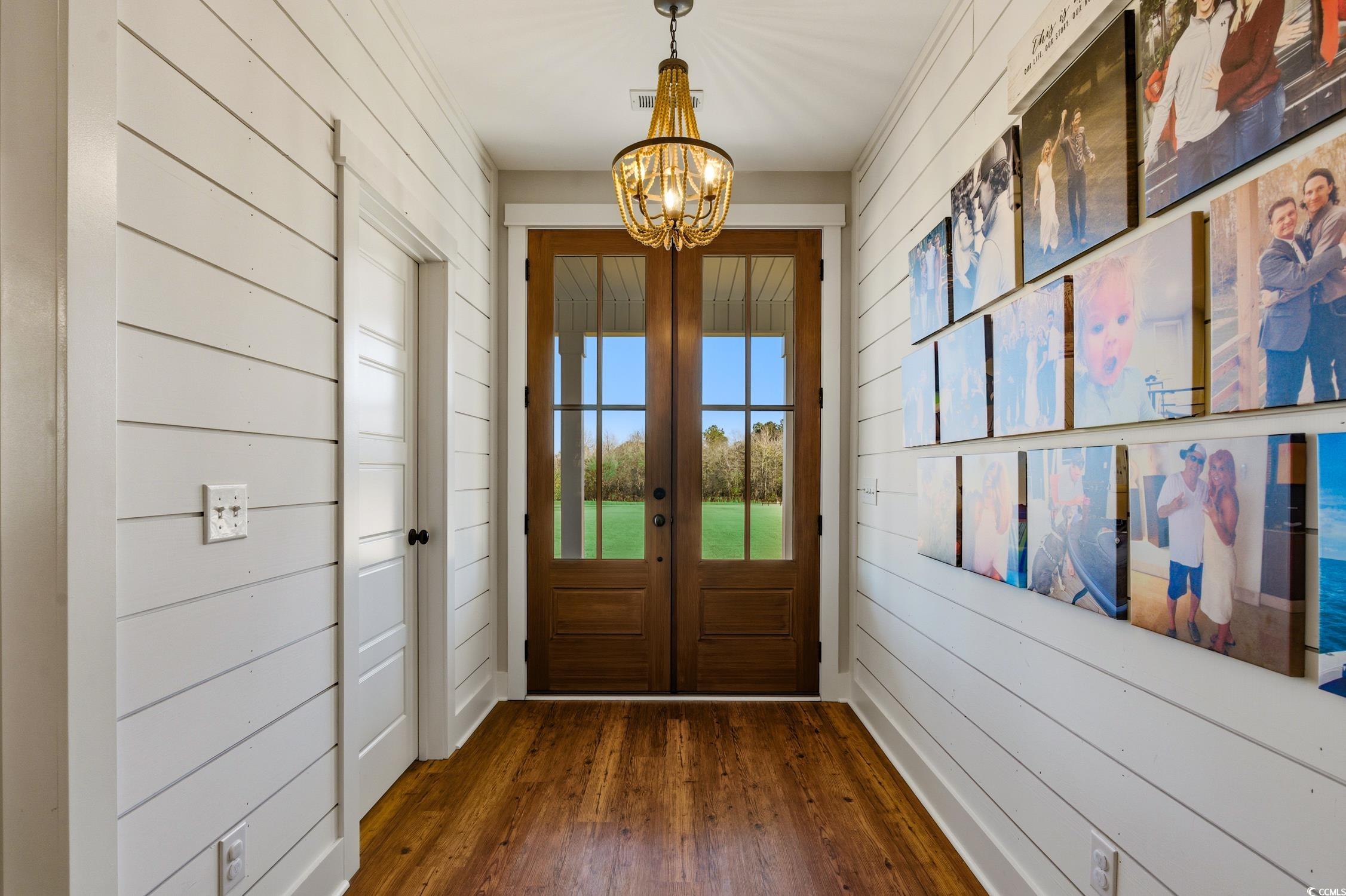 851 Dog Bluff Road Galivants Ferry, SC 29544 - Photo 2 of 25 Doorway with wooden walls, a chandelier, wood finished floors, and french doors