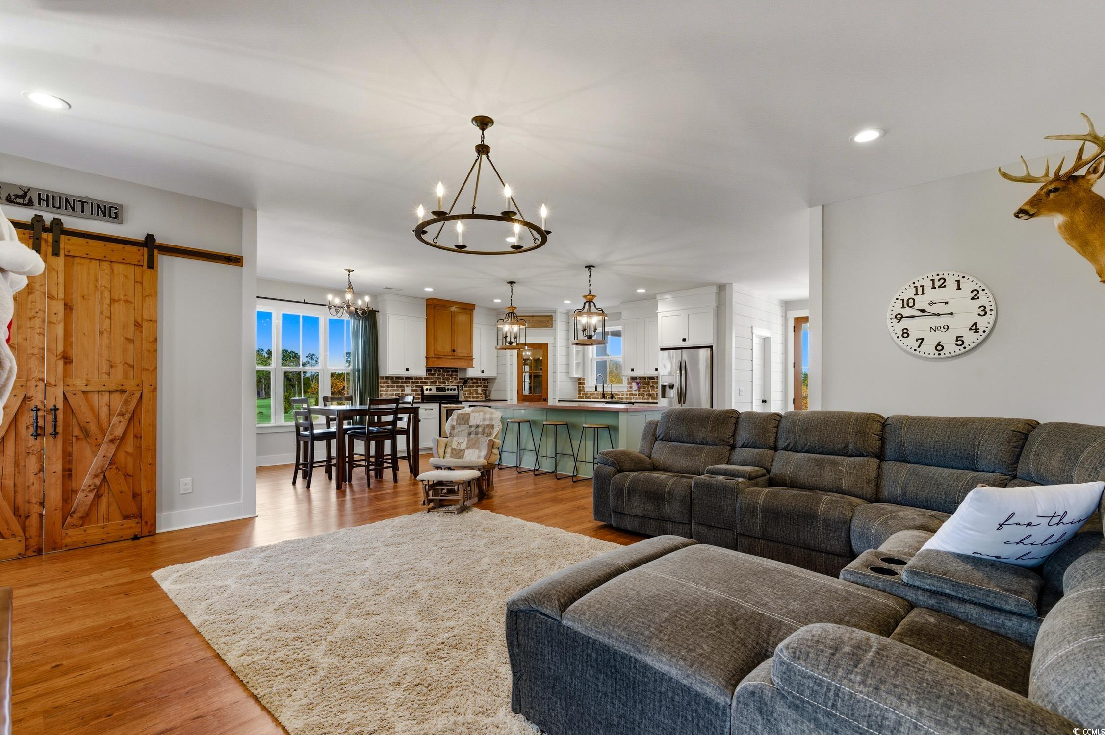 851 Dog Bluff Road Galivants Ferry, SC 29544 - Photo 8 of 25 Living room featuring a barn door, recessed lighting, light wood finished floors, and a chandelier