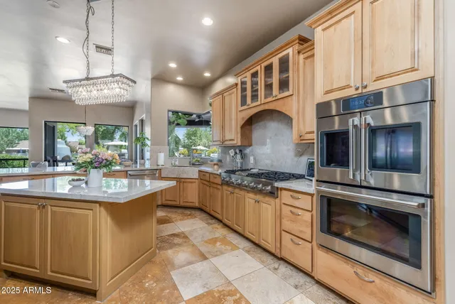 a kitchen with granite countertop a sink stainless steel appliances and cabinets