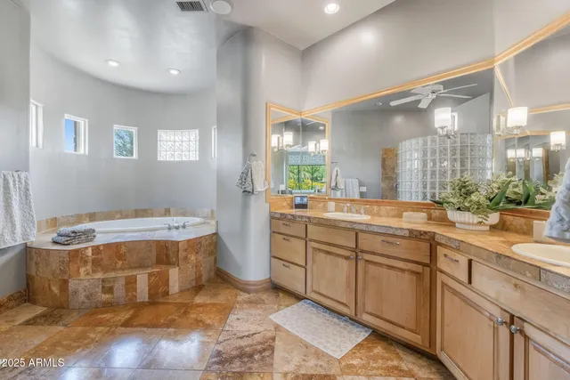 a en suite bathroom with a granite countertop sink and a mirror