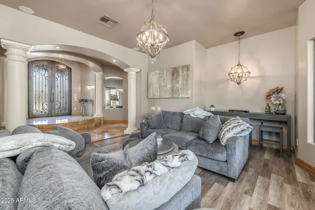 a living room with furniture and a chandelier