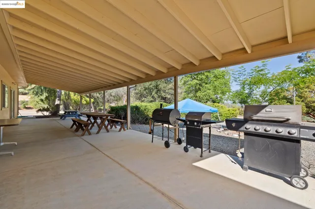 a view of a patio with table and chairs under an umbrella