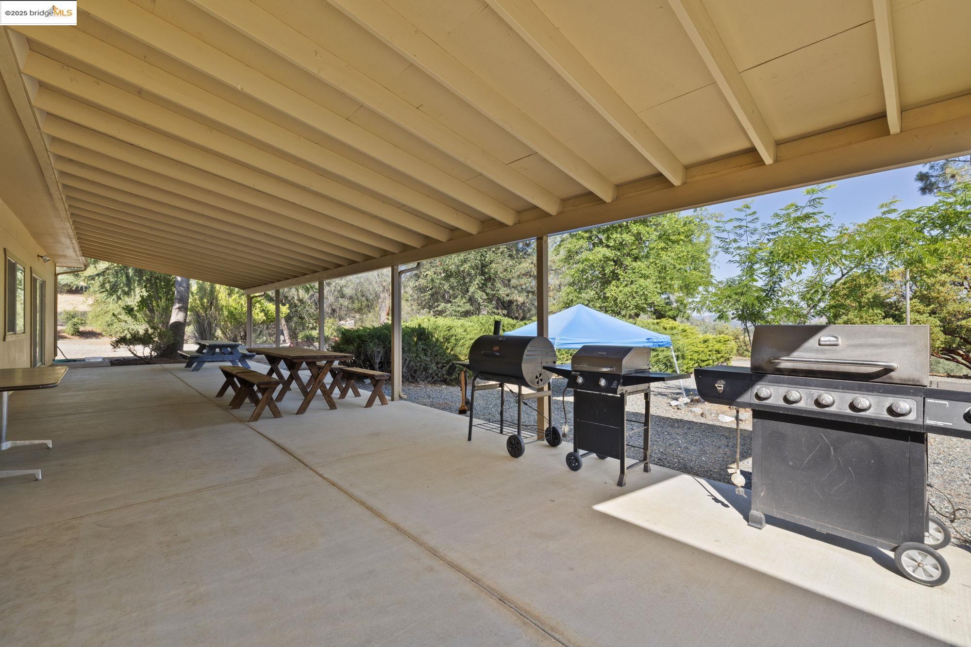 8400 Old Melones Dam Road, Unit 52 Jamestown, CA 95327 - Photo 13 of 21 a view of a patio with table and chairs under an umbrella
