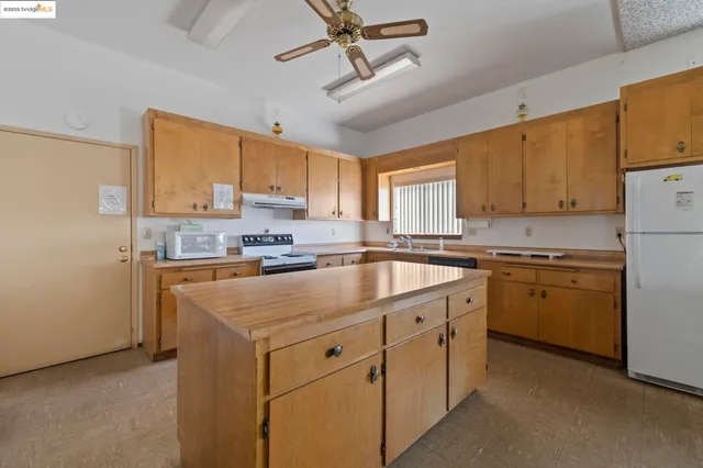 a kitchen with cabinets appliances a sink and a window
