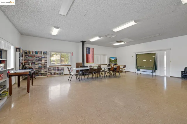 a view of a big room with dining table and chairs