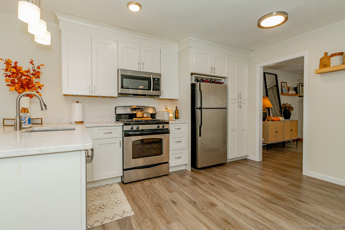 27 Deer Run Trail Manchester, CT 06042 - Photo 3 of 40 a kitchen with a refrigerator sink and white cabinets