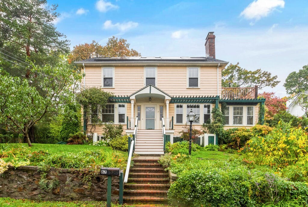 a view of a house with a yard and potted plants