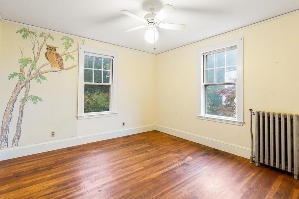 67 Coolidge Road Arlington, MA 02476 - Photo 21 of 34 a view of an empty room with wooden floor and a window