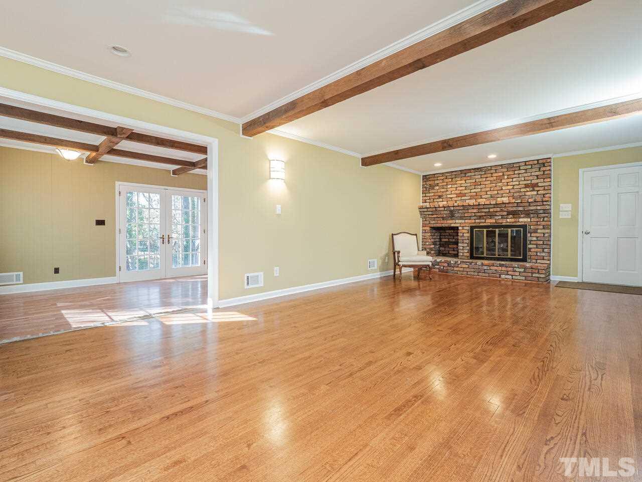 4604 Fernham Place Raleigh, NC 27612 - Photo 9 of 30 a view of empty room with wooden floor and fireplace