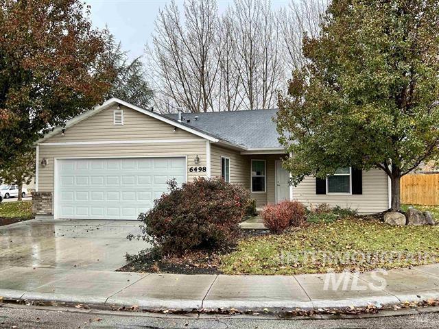 Single story home with concrete driveway, an attached garage, and a porch